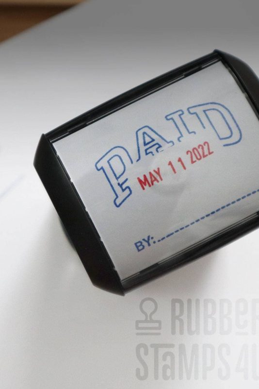 Custom Paid on Date stamp with example imprint on paper